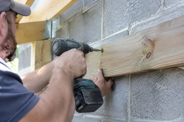 Fixation d'une panne murale de pergola bois adossée sur un mur porteur en parpaing