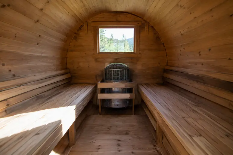 Intérieur d'un sauna tonneau montrant la paroi courbe et l'agencement des bancs en bois