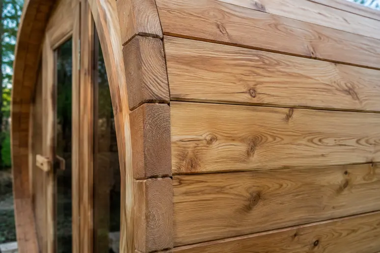 Gros plan sur l'épaisseur des douelles en bois d'un sauna tonneau de jardin