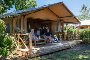 Aménagement spacieux et chaleureux à l'intérieur d'une tente lodge camping tout confort en bois et toile