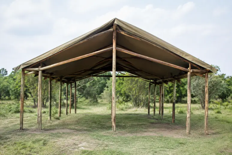 Ossature en bois d'une tente lodge de base installée sur un terrain naturel